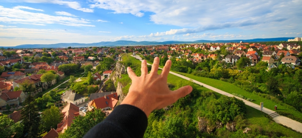 Beziehung scheitert am Haus – weil jeder ein`s hat…Ein Mann berichtet Hand vor einem Haus, vor Häusern