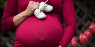 Schwanger und plötzlich Witwe: Eine Alleinerziehende erzählt Schwangere Frau mit Babyschuhen