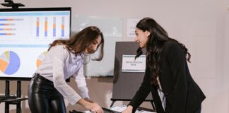 Berufseinsteiger: Marketing-Professor rät vom Homeoffice ab Zwei Frauen bereiten Business-Event vor