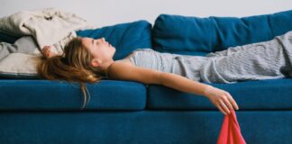„Mental Load“ ein Modebegriff? Web-Community diskutiert Frau liegt kaputt auf dem Sofa