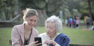 Kurzfristige Pflege von Angehörigen: Wer bekommt Pflegeunterstützungsgeld? Junge Frau mit Seniorin auf der Bank