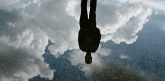 Einsam oder allein? Ein Vater stößt emotionale Diskussion im Web an Mann spiegelt sich in Pfütze