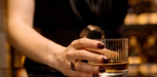 Betrugsmasche im Web: Wenn ein Social Media-Moment den Urlaub ruiniert Frau mit Whiskey Glas