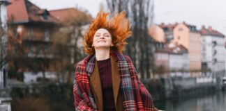 Wohlfühlen während der Periode: 6 Expertinnen teilen ihr Wissen Frau mit rotem Haar, gut gelaunt