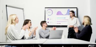 Feedback im Beruf: Für Frauen oft weniger hilfreich Ein Team im Job gibt einer Frau Feedback